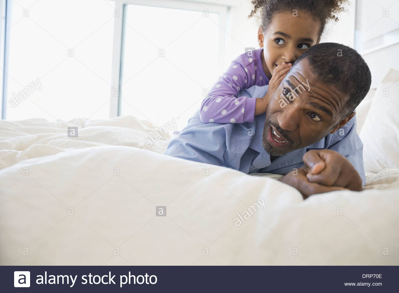 Girl whispering in fathers ear Stock Photo
