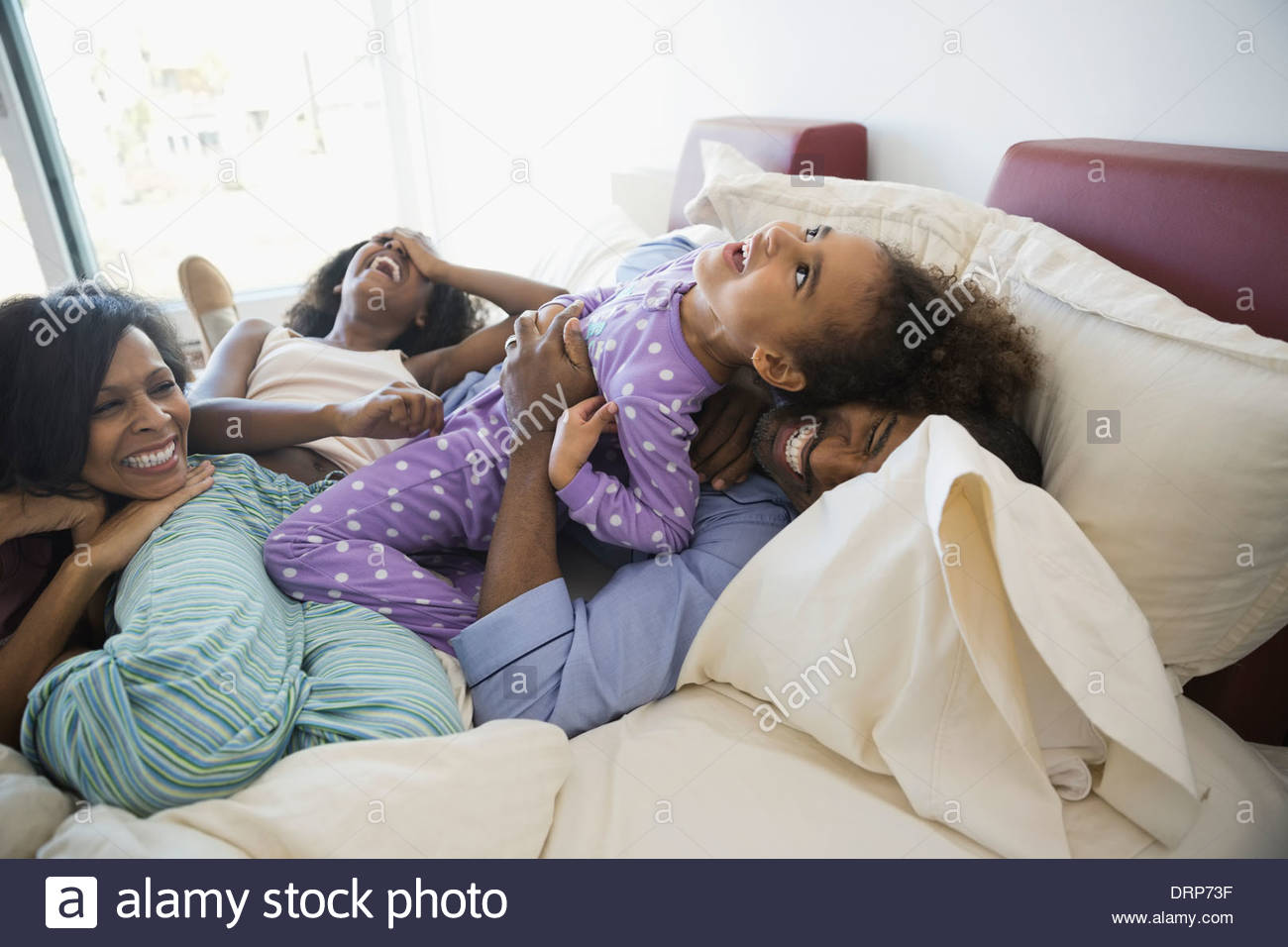 Playful family in bed Stock Photo
