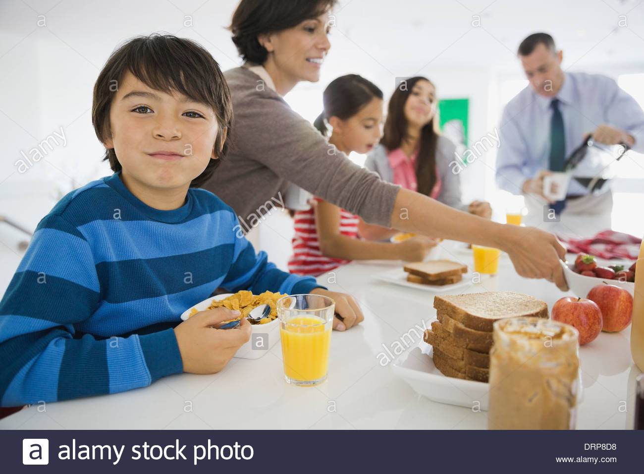 Portrait of boy having breakfast with family Stock Photo