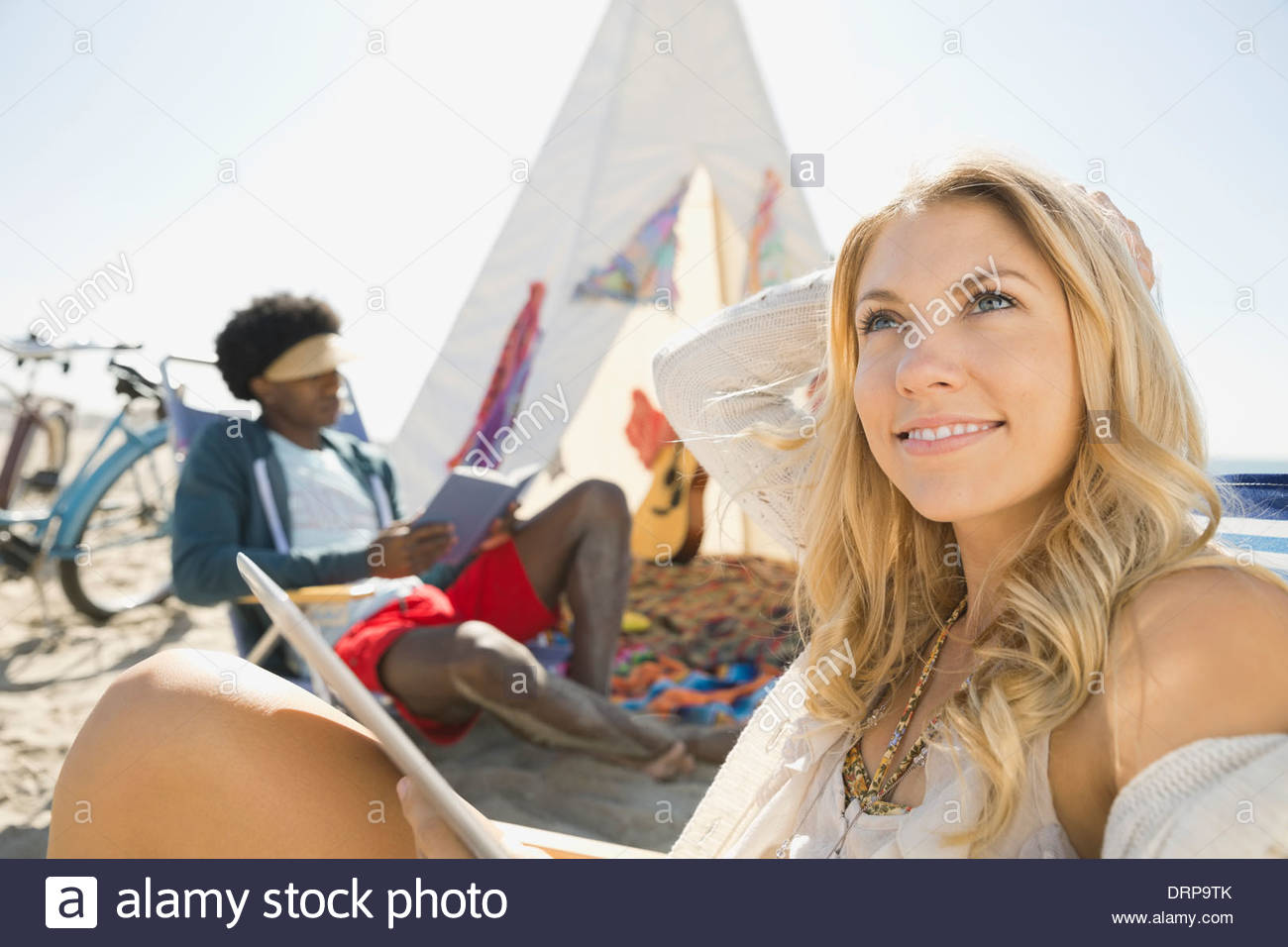 Thoughtful woman daydreaming on beach Stock Photo