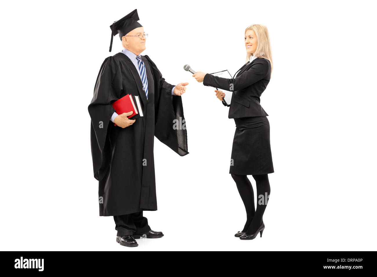 Full length portrait of young female interviewing mature man in graduation gown Stock Photo