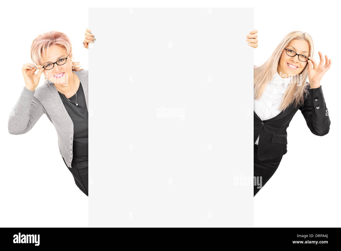 Young woman and mature lady with glasses standing behind blank panel Stock Photo
