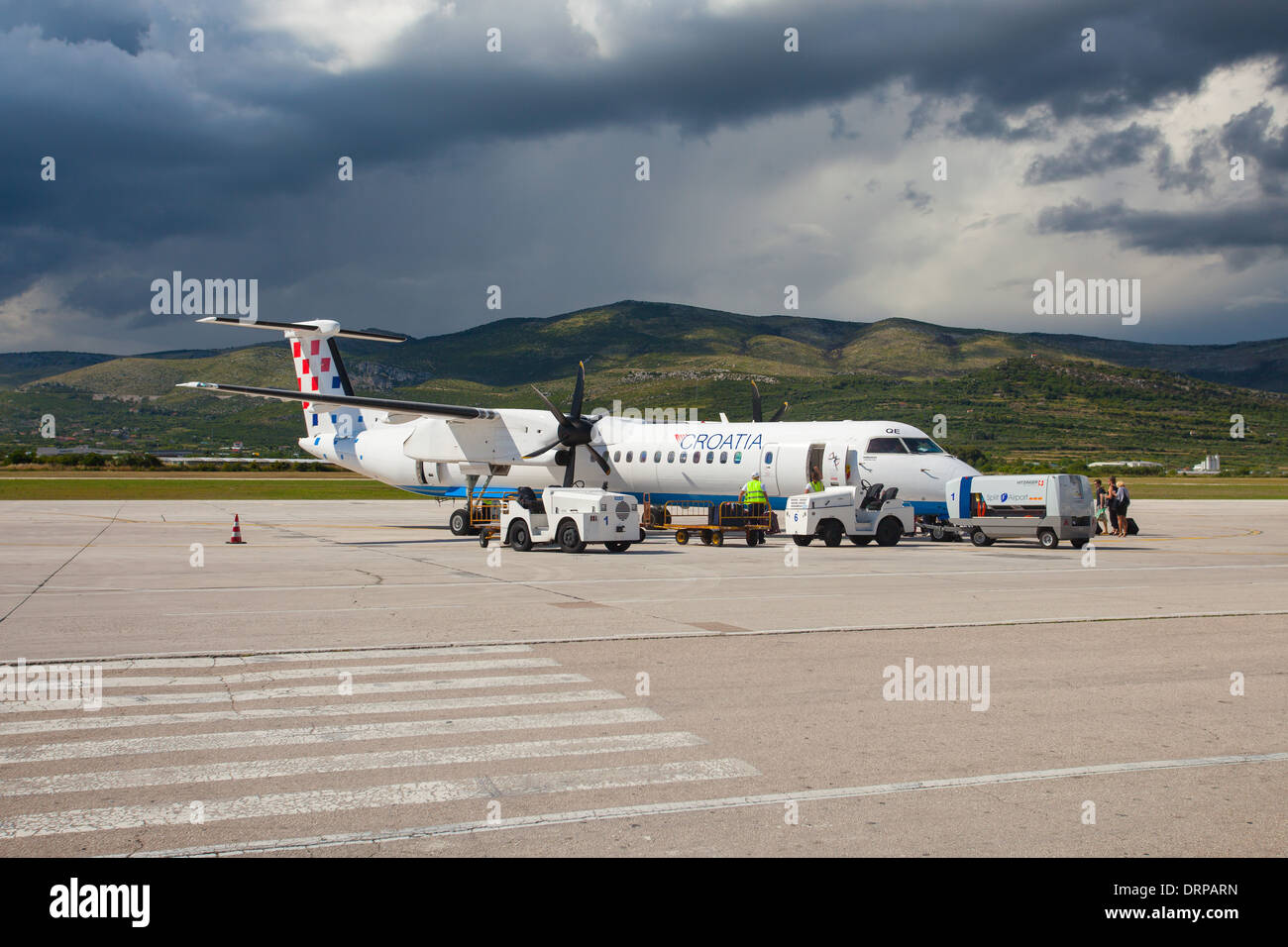 SPLIT, CROATIA - JUN 6: Croatia Airlines Dash 8 Q400 parked on a runway of Split Airport during boarding on June 6, 2013 Stock Photo