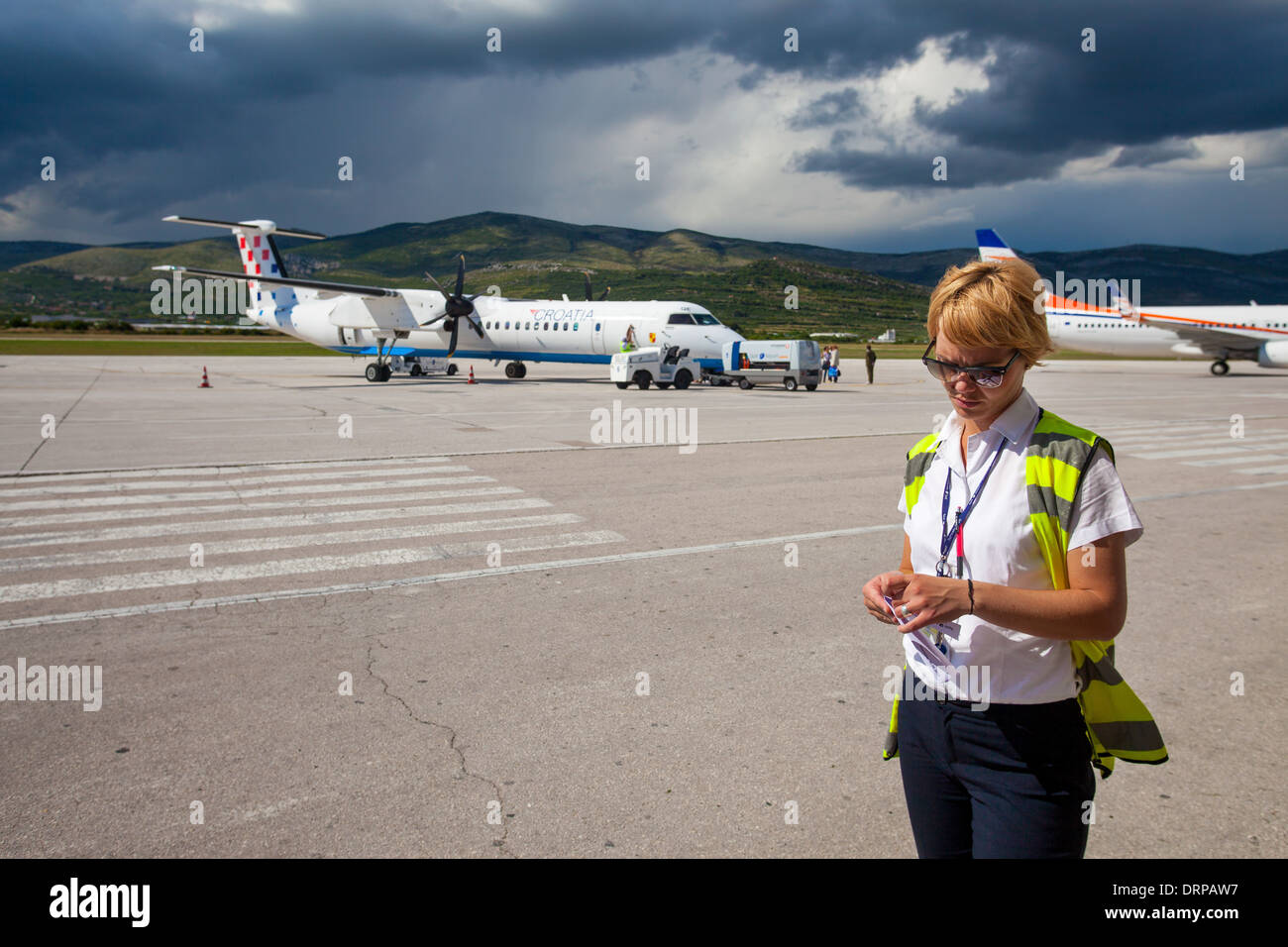 SPLIT, CROATIA - JUN 6: Airport staff standing on a runway of Split Airport during boarding on June 6, 2013 in Split, Croatia. Stock Photo