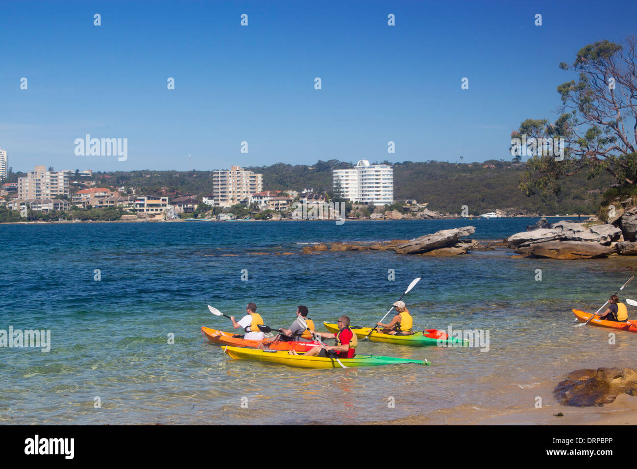 Reef Beach North Harbour looking across to Manly with kayakers about to paddle away from beach Sydney NSW Australia Stock Photo