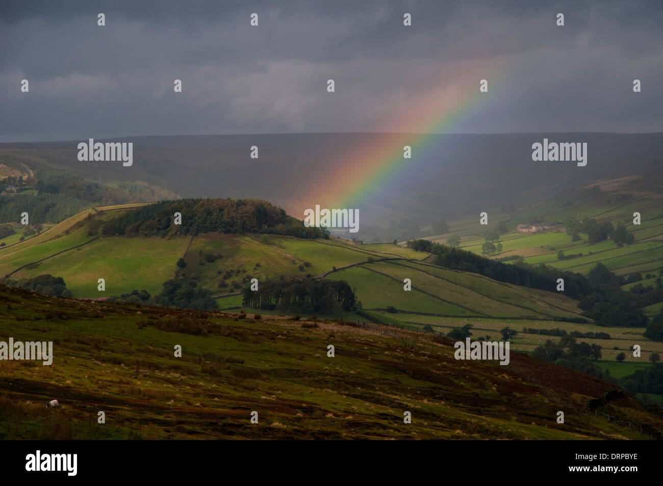 Rain clouds and a rainbow over Rosedale as seen from Chimney Bank at the edge of Spaunton Moor in the North York Moors NP Stock Photo