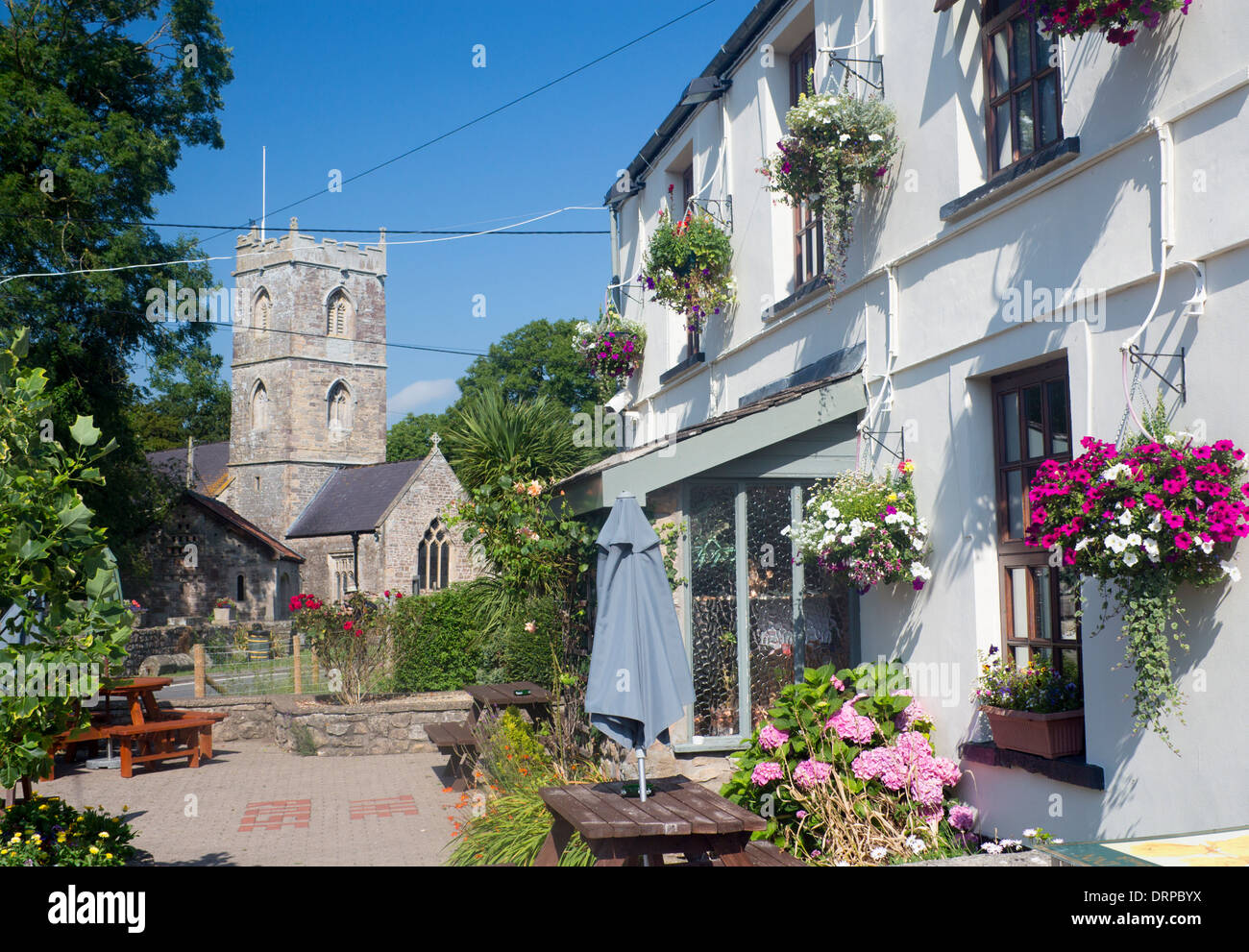 Redwick exterior of The Rose pub with flower baskets and St Thomas' church County of Newport Gwent Levels South Wales UK Stock Photo