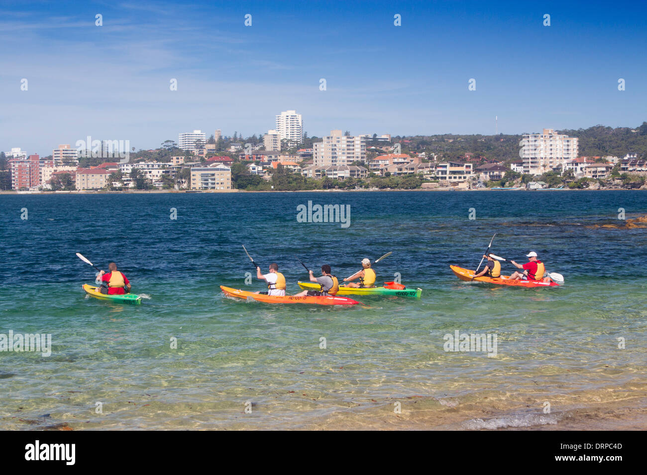 Reef Beach North Harbour looking across to Manly with kayakers paddling away from beach Sydney NSW Australia Stock Photo