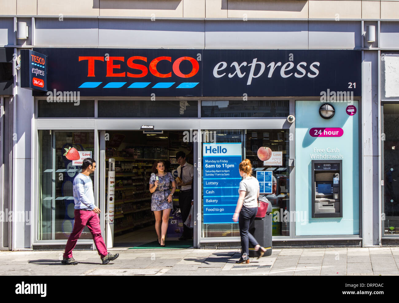 London, UK - 1st August 2013: The outside of a Tesco Express Store with people going past and in the shop Stock Photo