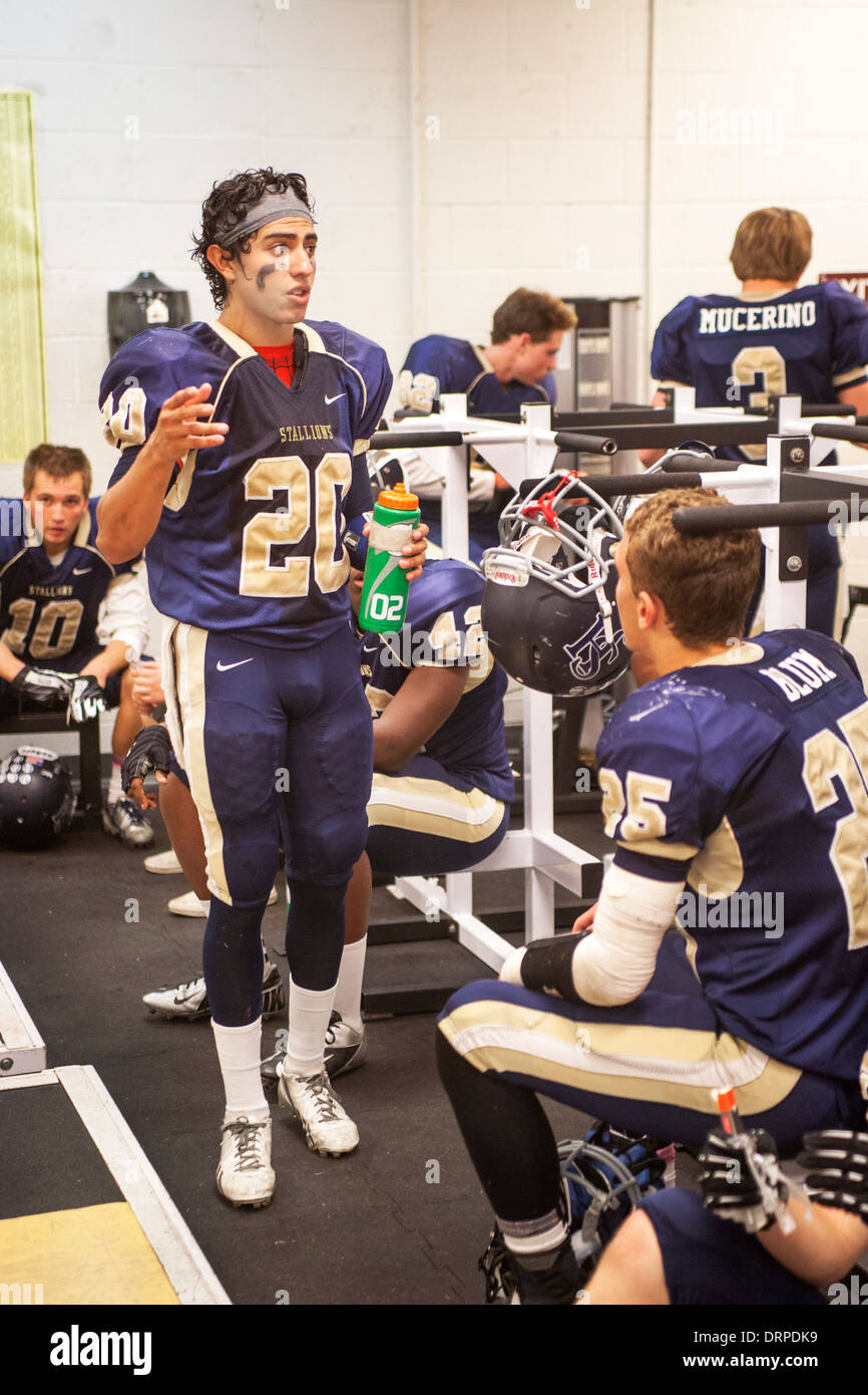 High school football players discuss the game during half time in their locker room in San Juan Capistrano, CA. Stock Photo