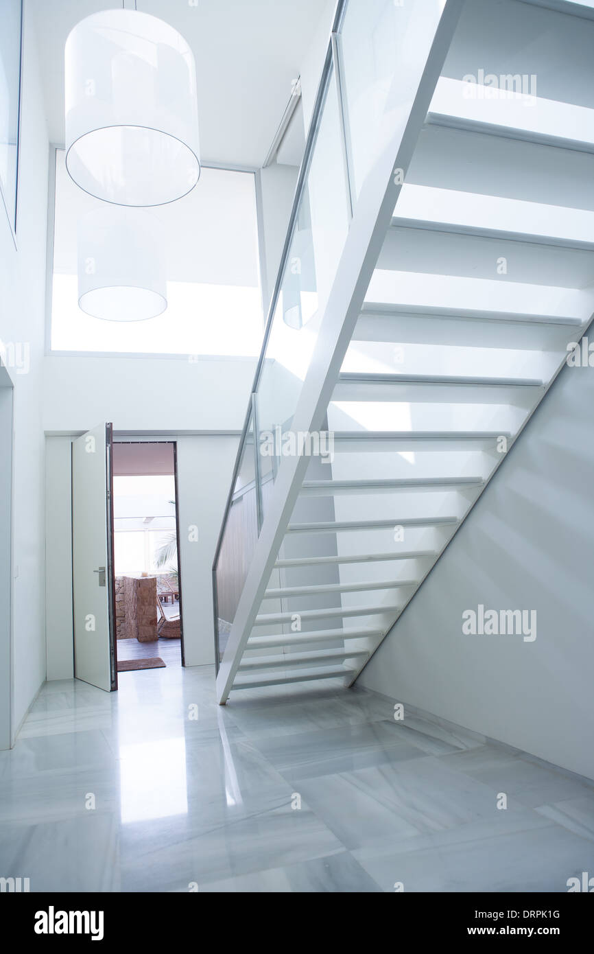 Modern white house entrance hall lobby with stairway and light coming in Stock Photo