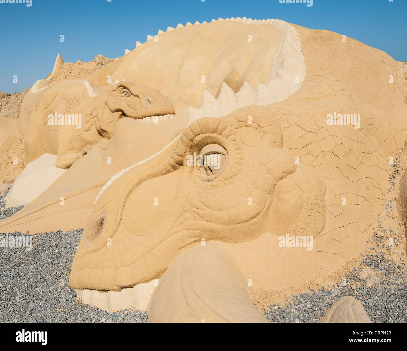 Closeup detail of large sand sculpture statue of a dinosaur at sand city theme park Stock Photo