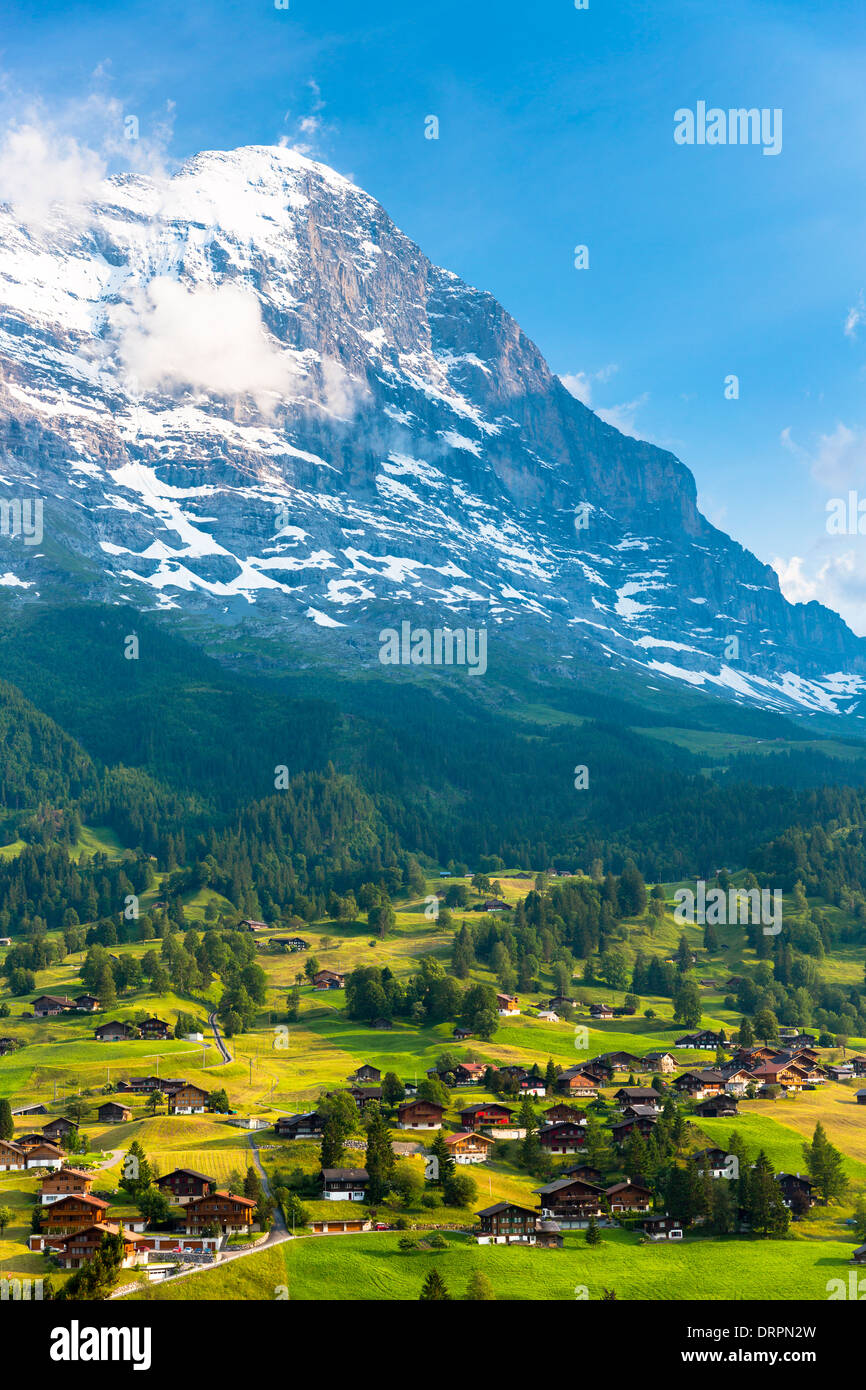 The town of Grindelwald beneath the Eiger mountain North Wall in the Swiss Alps under cerulean sky in the Bernese Oberland, Switzerland Stock Photo