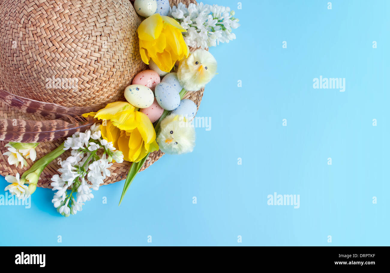 Straw hat decorated for easter with flowers, chicks and easter eggs Stock Photo
