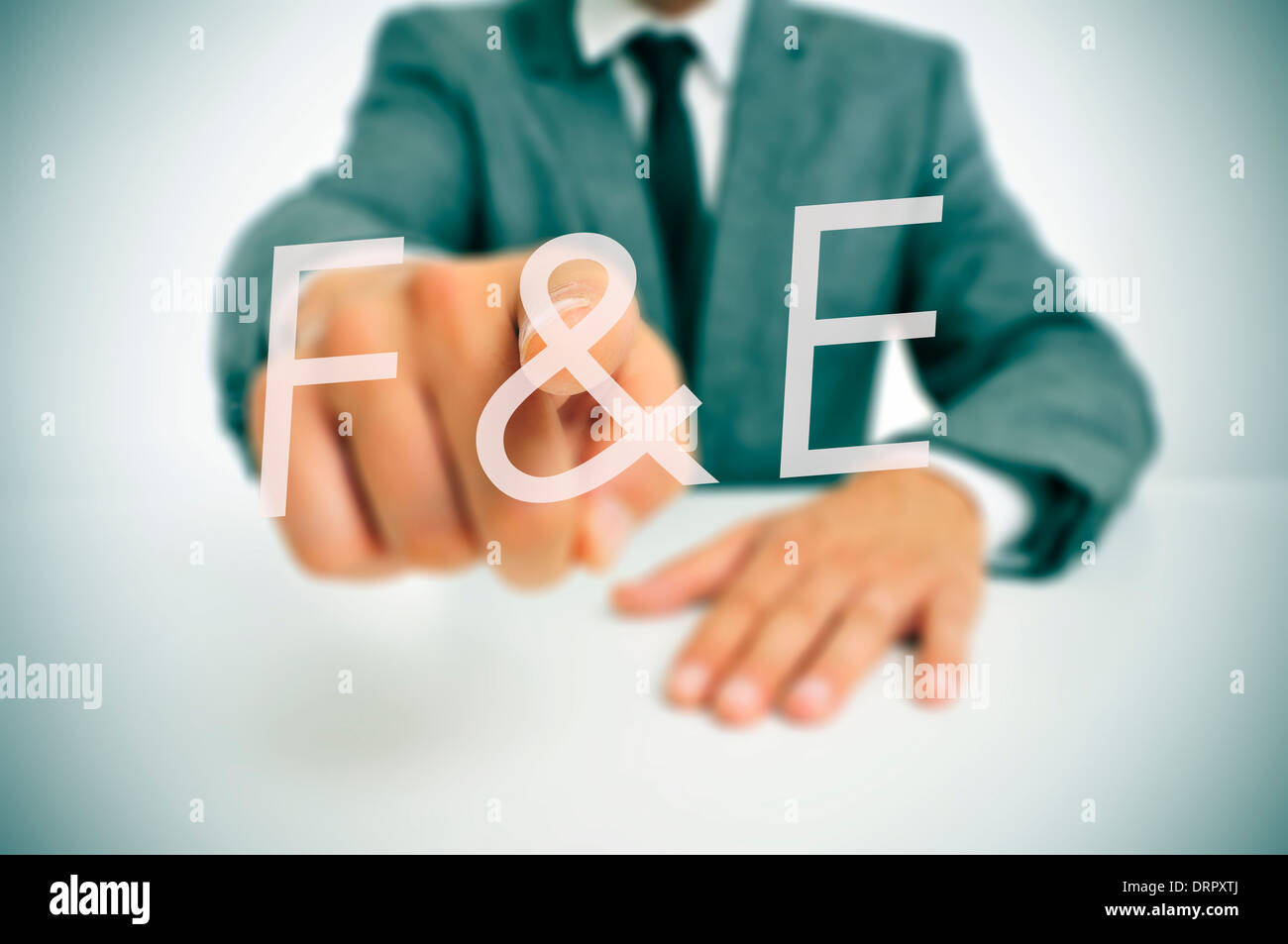 businessman wearing a suit pointing to the term F and E, forschung und entwicklung, research and development in german, written Stock Photo