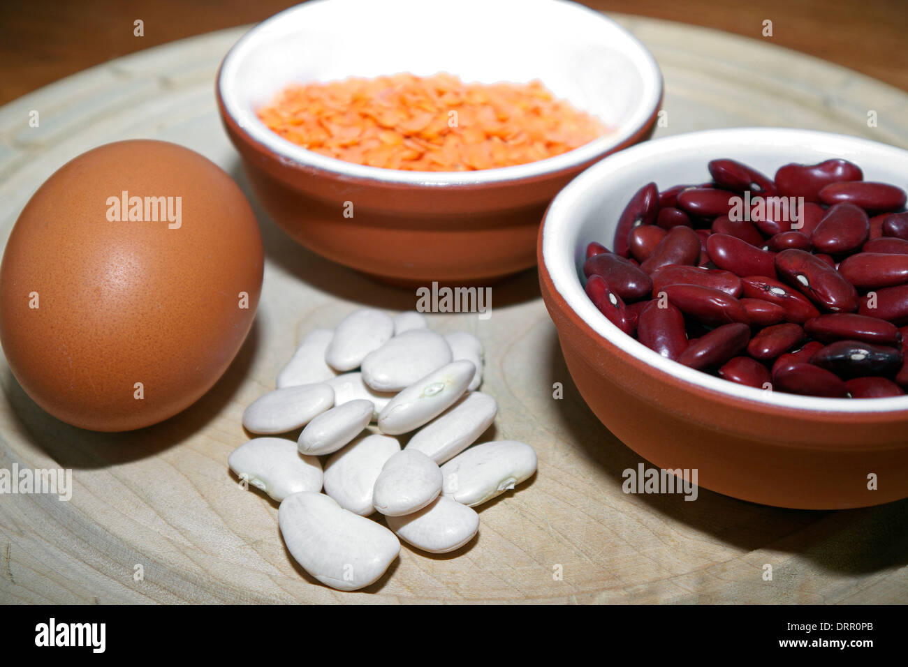 A still-life study of an egg,beans and red lentils. Stock Photo