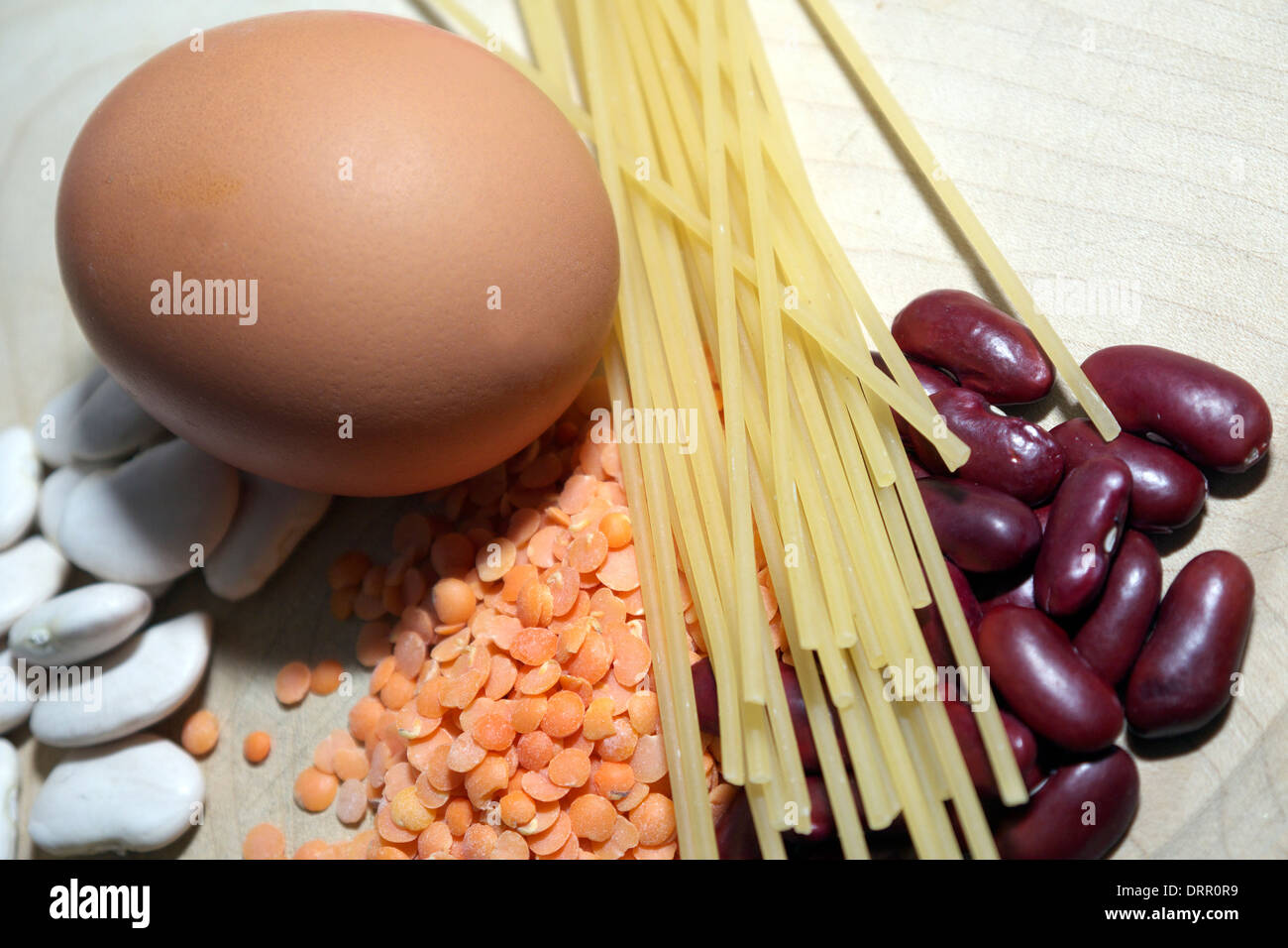 A still-life study of an egg,beans,pasta and red lentils. Stock Photo
