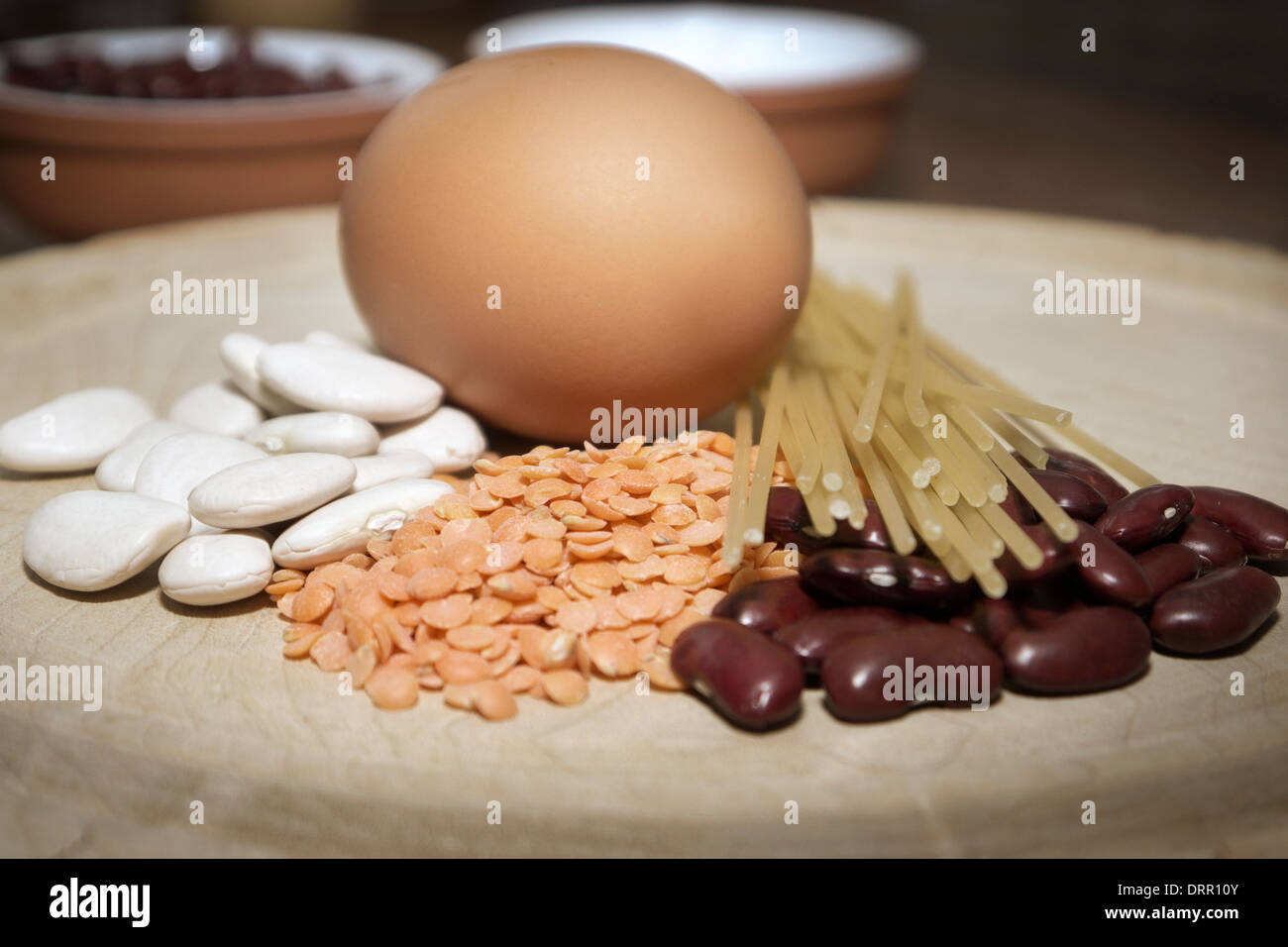 A still-life study of an egg, beans,pasta and red lentils. Stock Photo