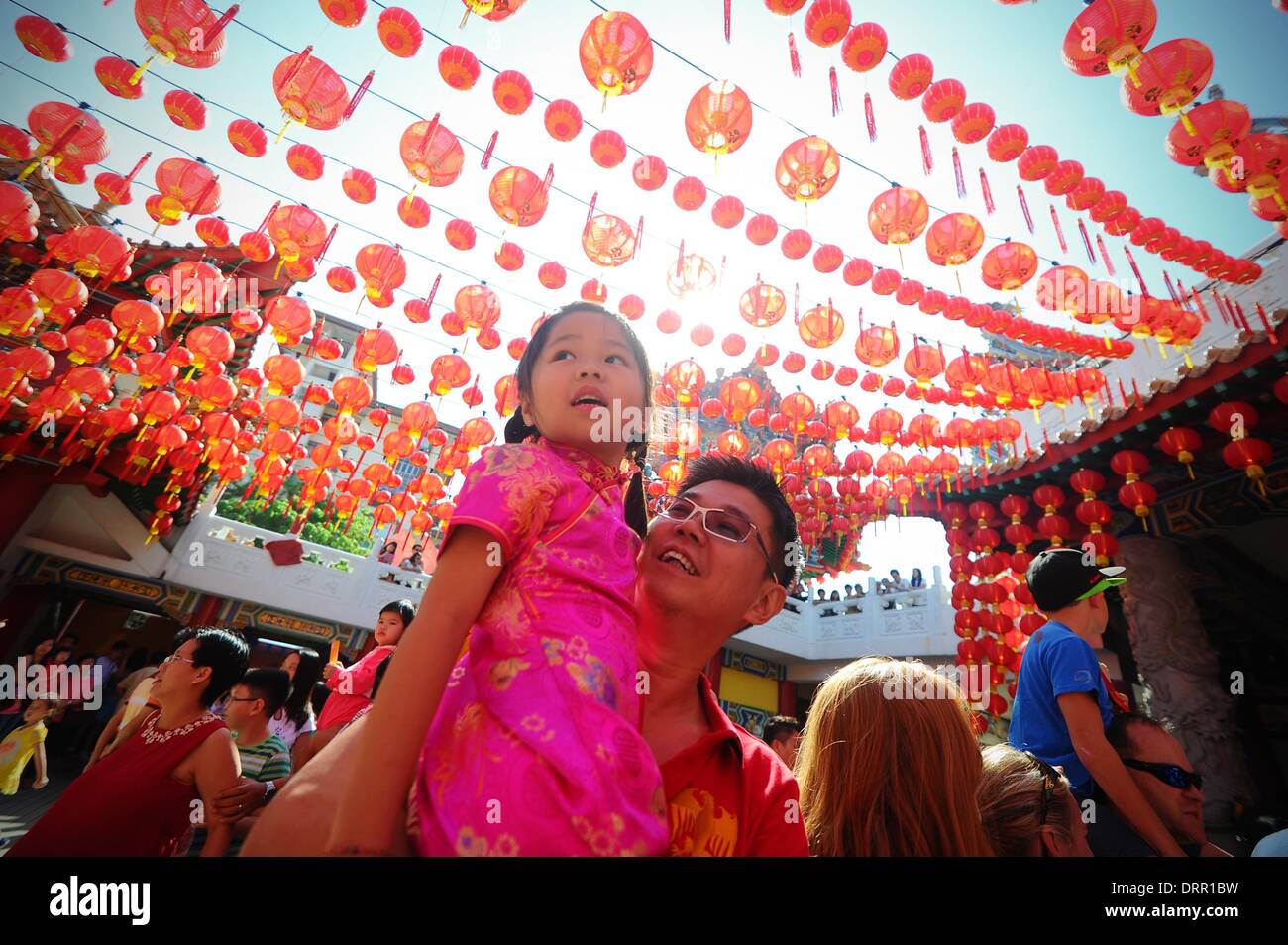 Kuala Lumpur, Malaysia. 31st Jan, 2014. A child sits on her father's shoulder enjoying the lion dance show during the first day of Chinese Lunar New Year at a temple outside Kuala Lumpur, Malaysia, Saturday, January 31, 2014. This year's Chinese Lunar New Year marks the beginning of the galloping horse according to the Chinese Zodiac calendar. Credit:  Joshua Paul/NurPhoto/ZUMAPRESS.com/Alamy Live News Stock Photo