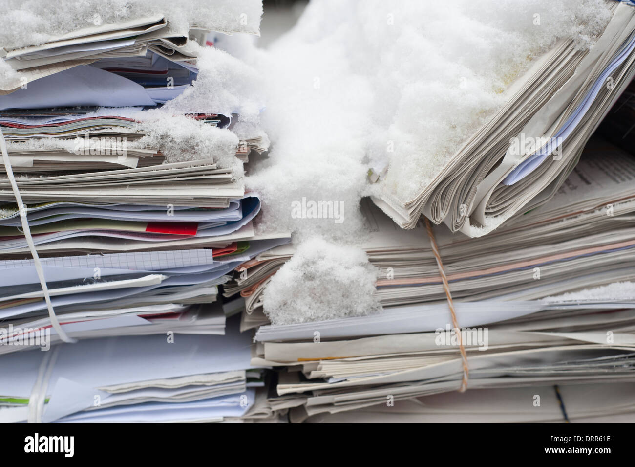 Bundled waste-paper covered with snow is ready to be collected and on a street in a residential area of Zurich, Switzerland. Stock Photo