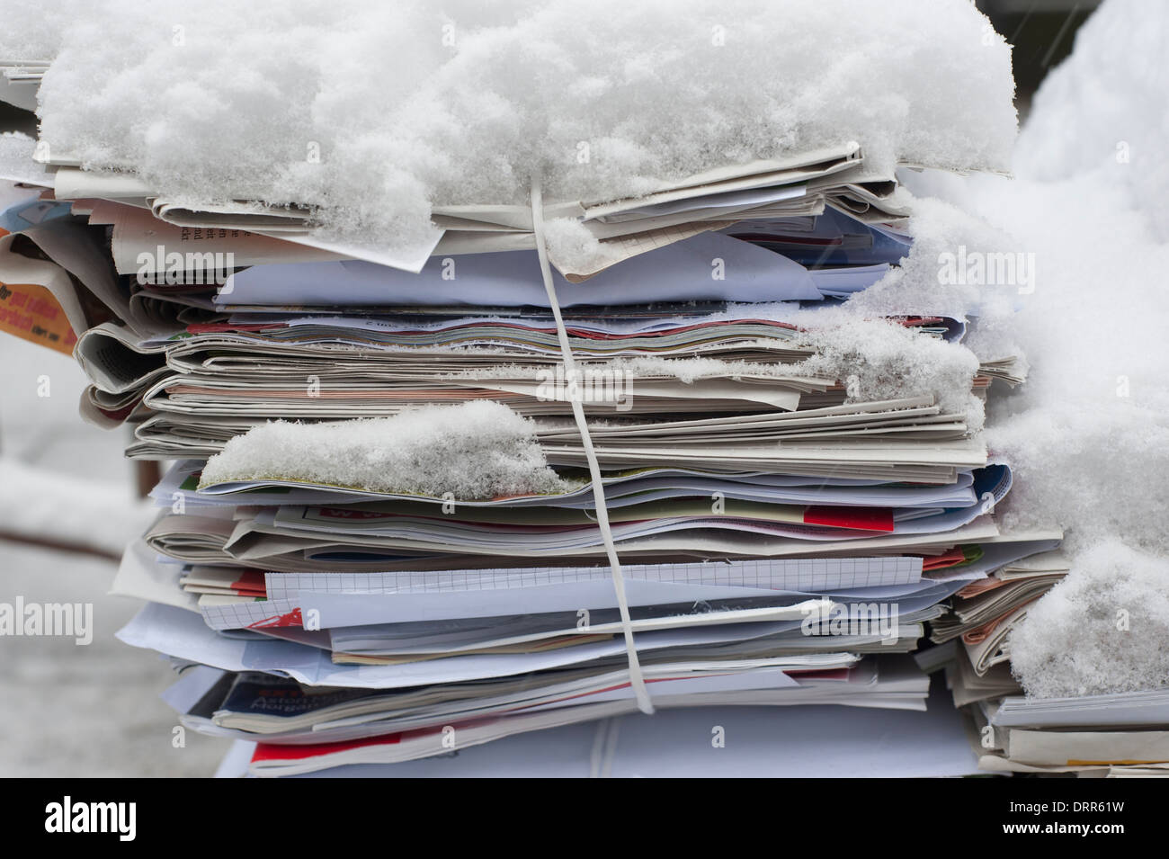 Bundled waste-paper covered with snow is ready to be collected and on a street in a residential area of Zurich, Switzerland. Stock Photo