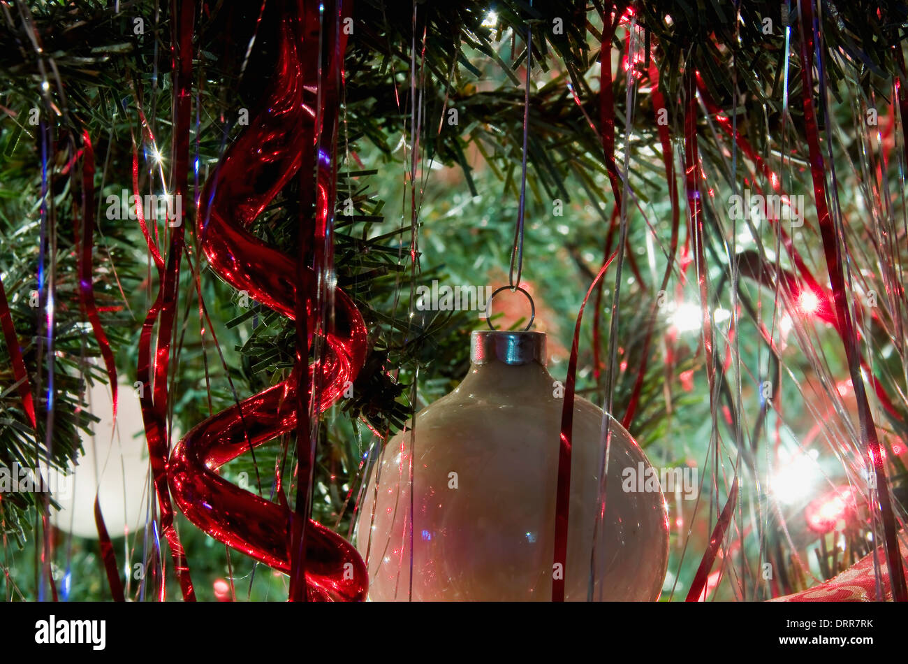 A White Ball And Red Icicle Decoration On A Christmas Tree Stock