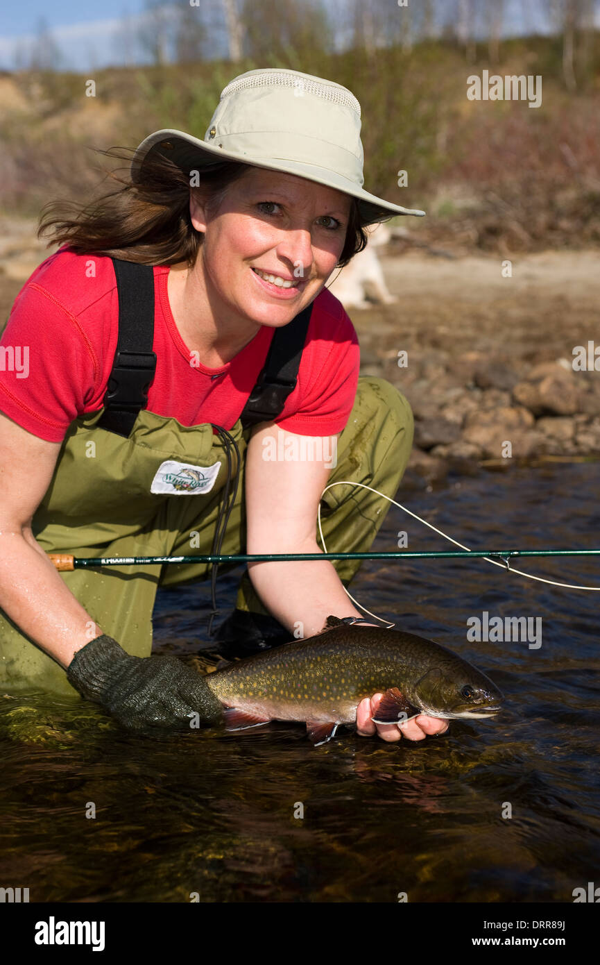 Woman holding a summer brook trout caught fly flishing. Stock Photo