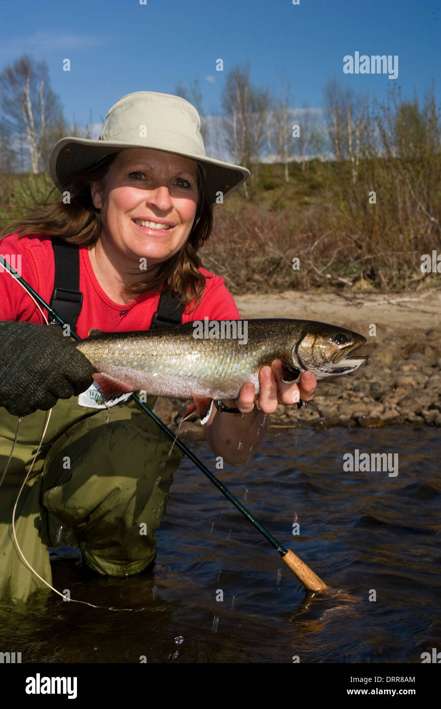Woman holding a summer brook trout caught fly flshing. Stock Photo