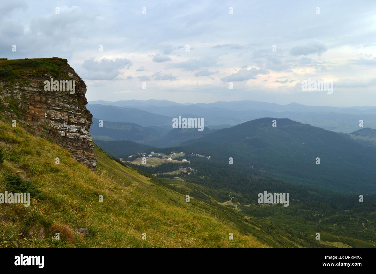 Stone boulder covered with grass in the mountains Stock Photo