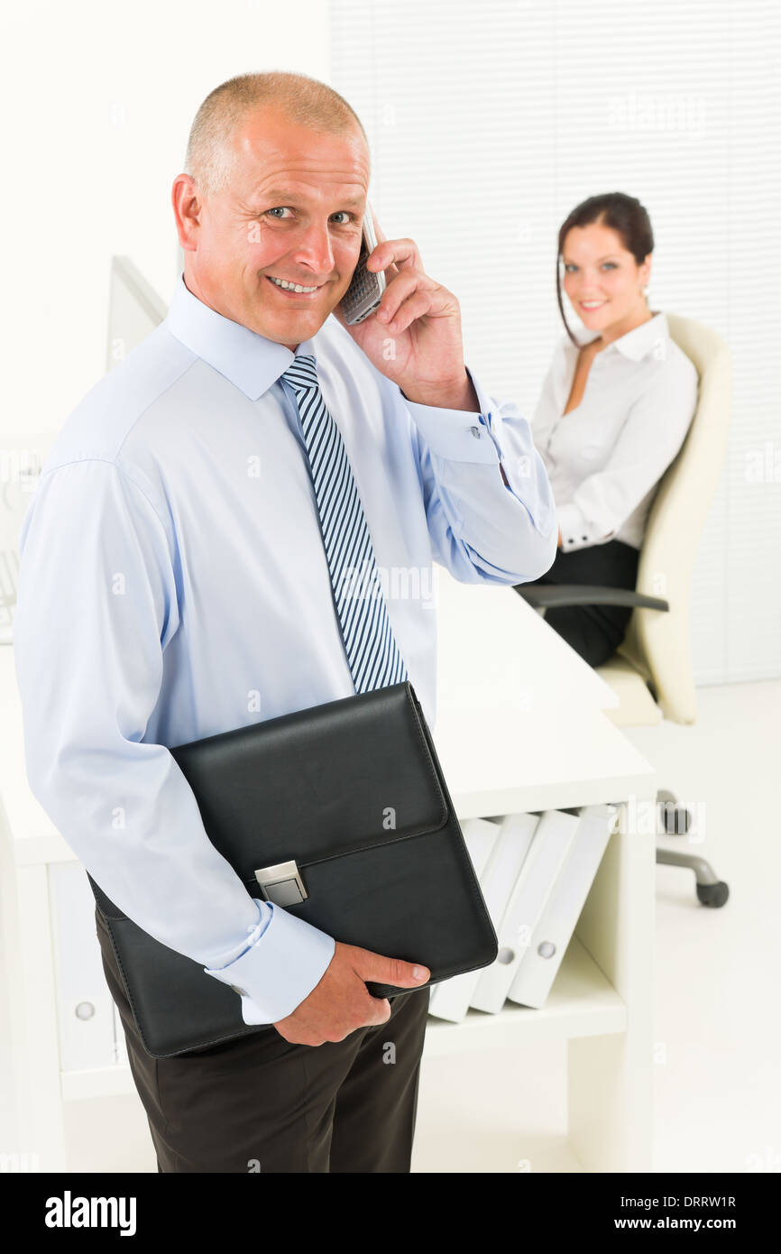 Mature businessman calling hold briefcase Stock Photo Alamy