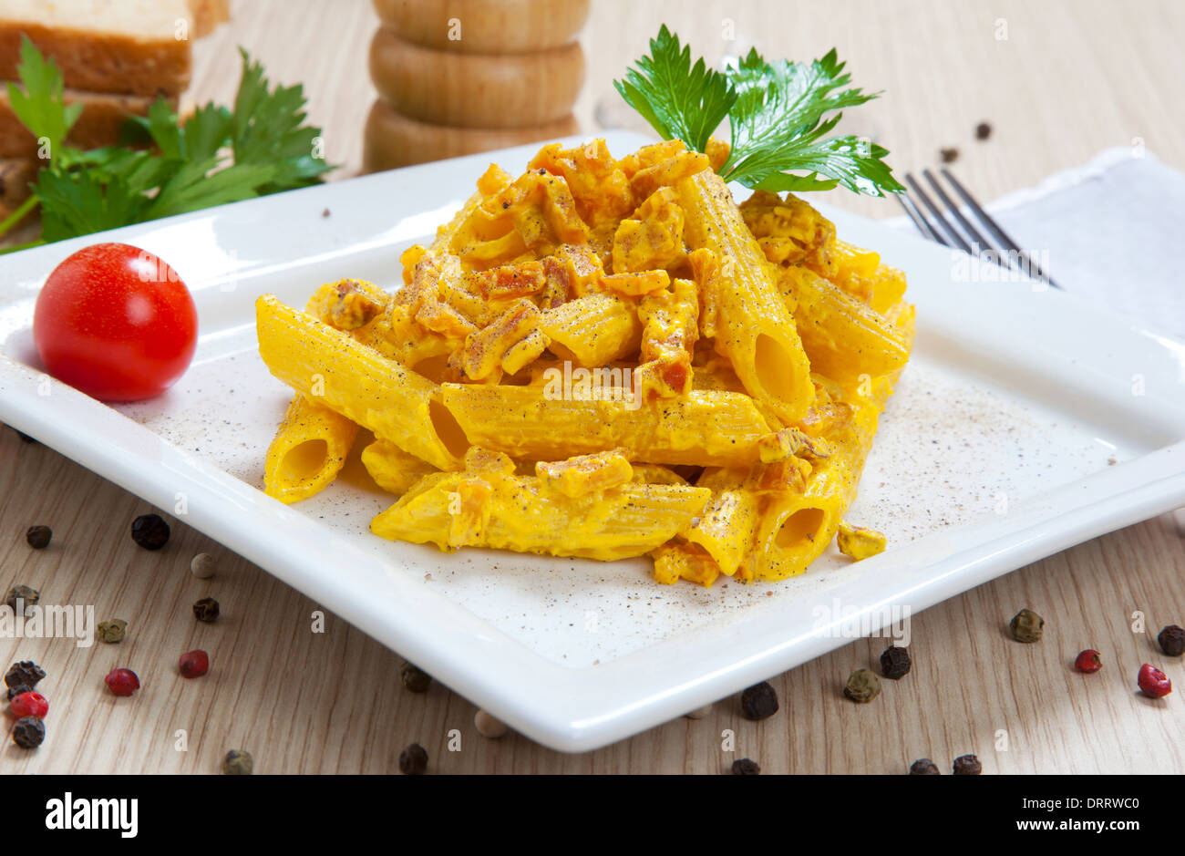 Penne with speck and saffron on a dish Stock Photo Alamy