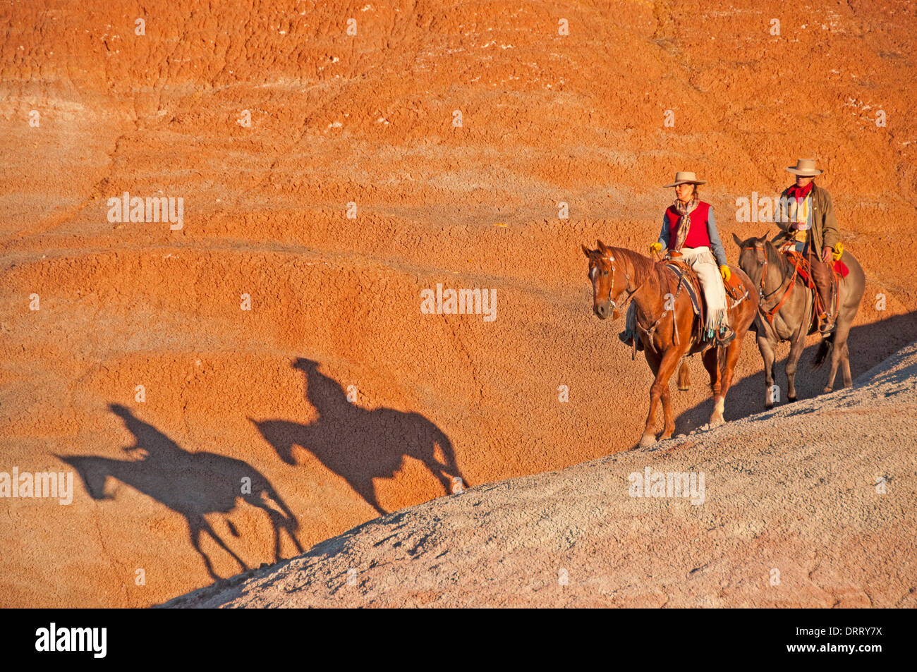 https://c8.alamy.com/comp/DRRY7X/a-cowgirl-and-cowboy-ride-their-horses-in-the-painted-hills-area-of-DRRY7X.jpg