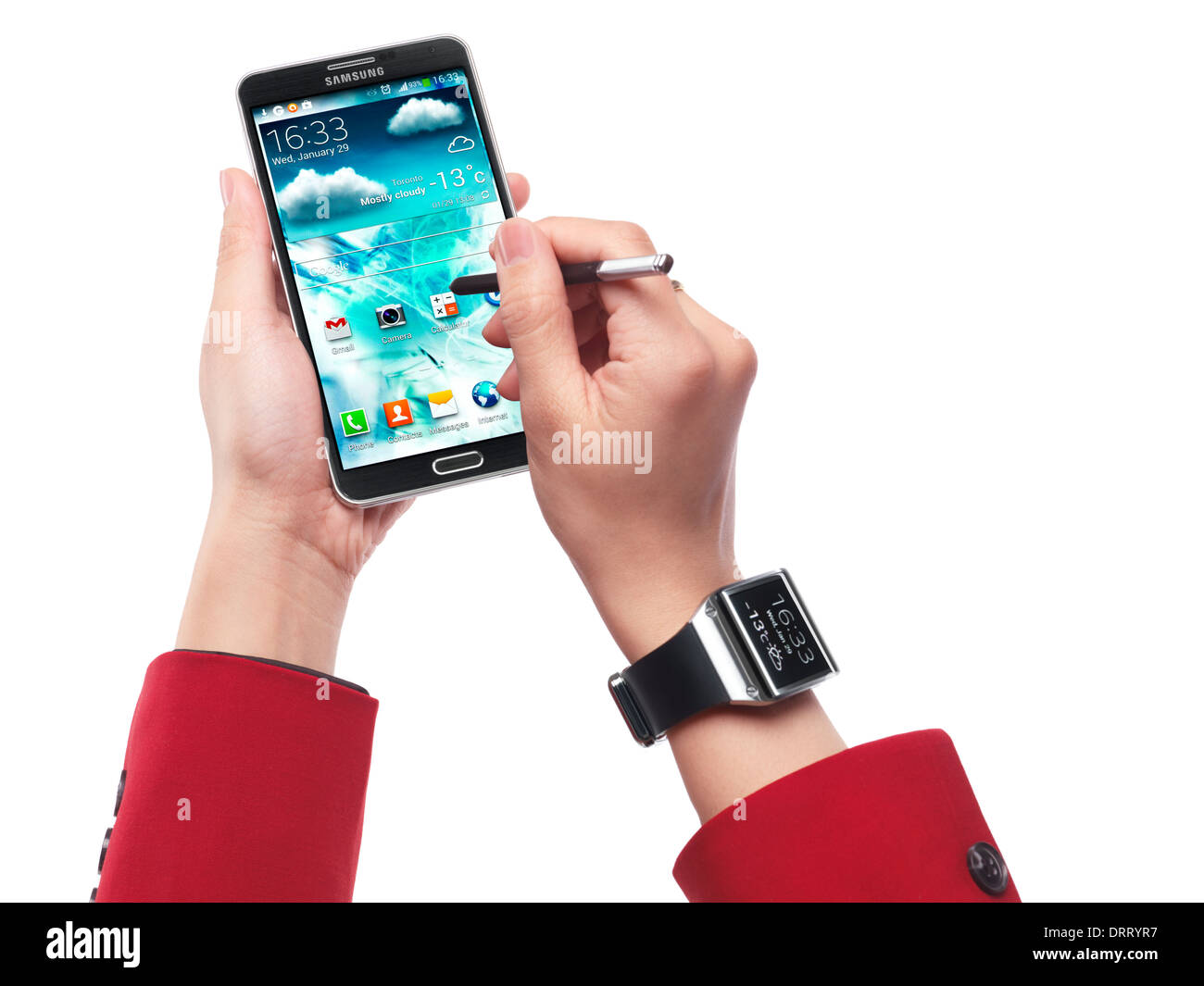 Woman wearing Samsung Galaxy Gear watch and using Galaxy Note III smartphone isolated on white background Stock Photo