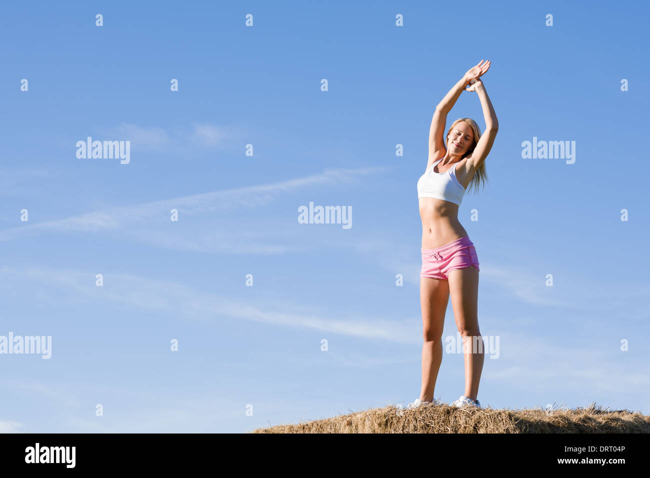 Stretching sport fit woman summer blue sky Stock Photo