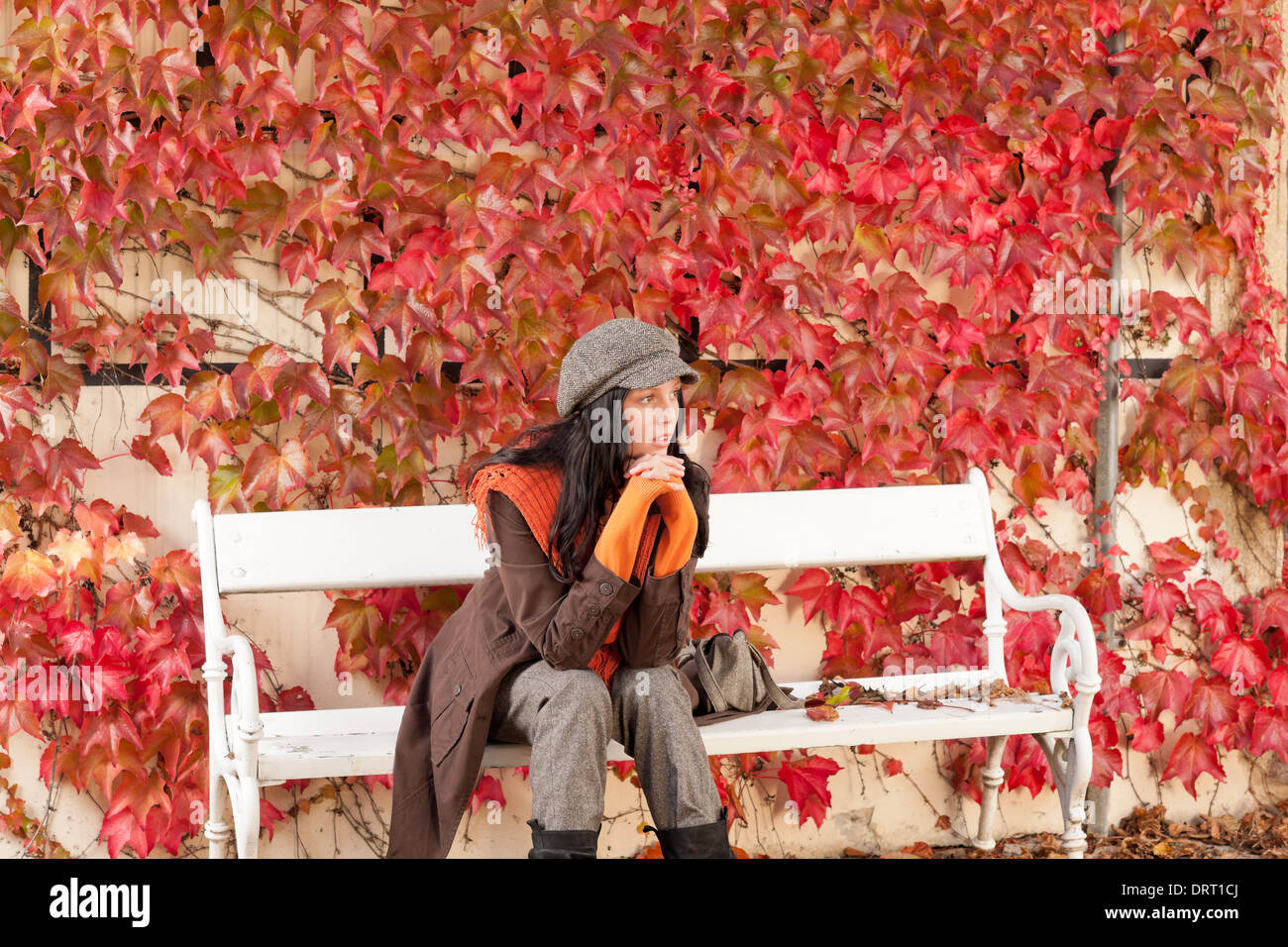 Autumn park bench young woman relaxing Stock Photo - Alamy