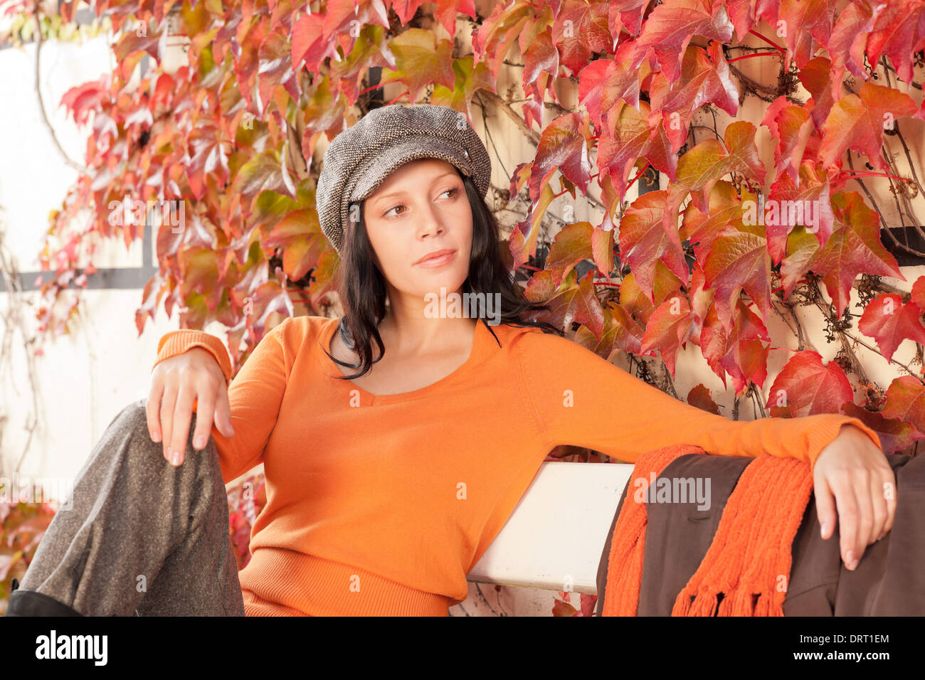 Autumn park bench young woman relaxing Stock Photo - Alamy