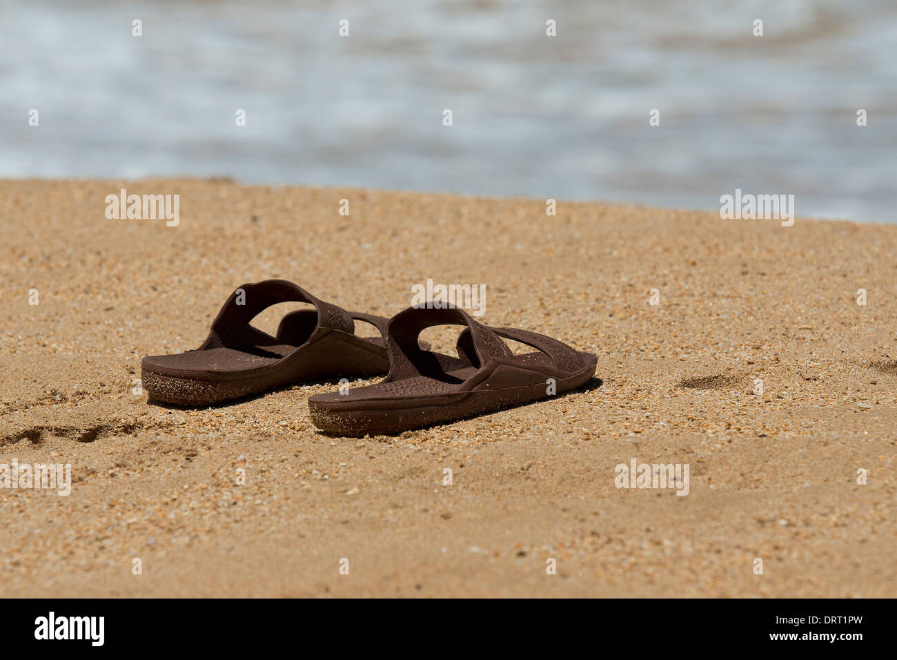 Sandals on the beach Stock Photo - Alamy