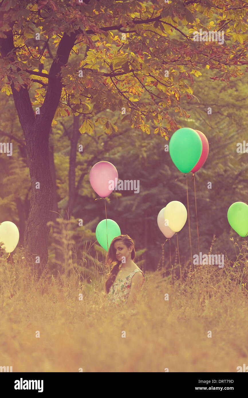 Girl sitting on balloons field Stock Photo - Alamy