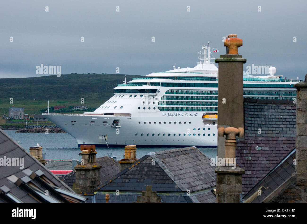 The cruise ship "Brilliance Of The Seas" moored in Bressay sound, viewed from the roof tops of Lerwick town, Shetland. Stock Photo