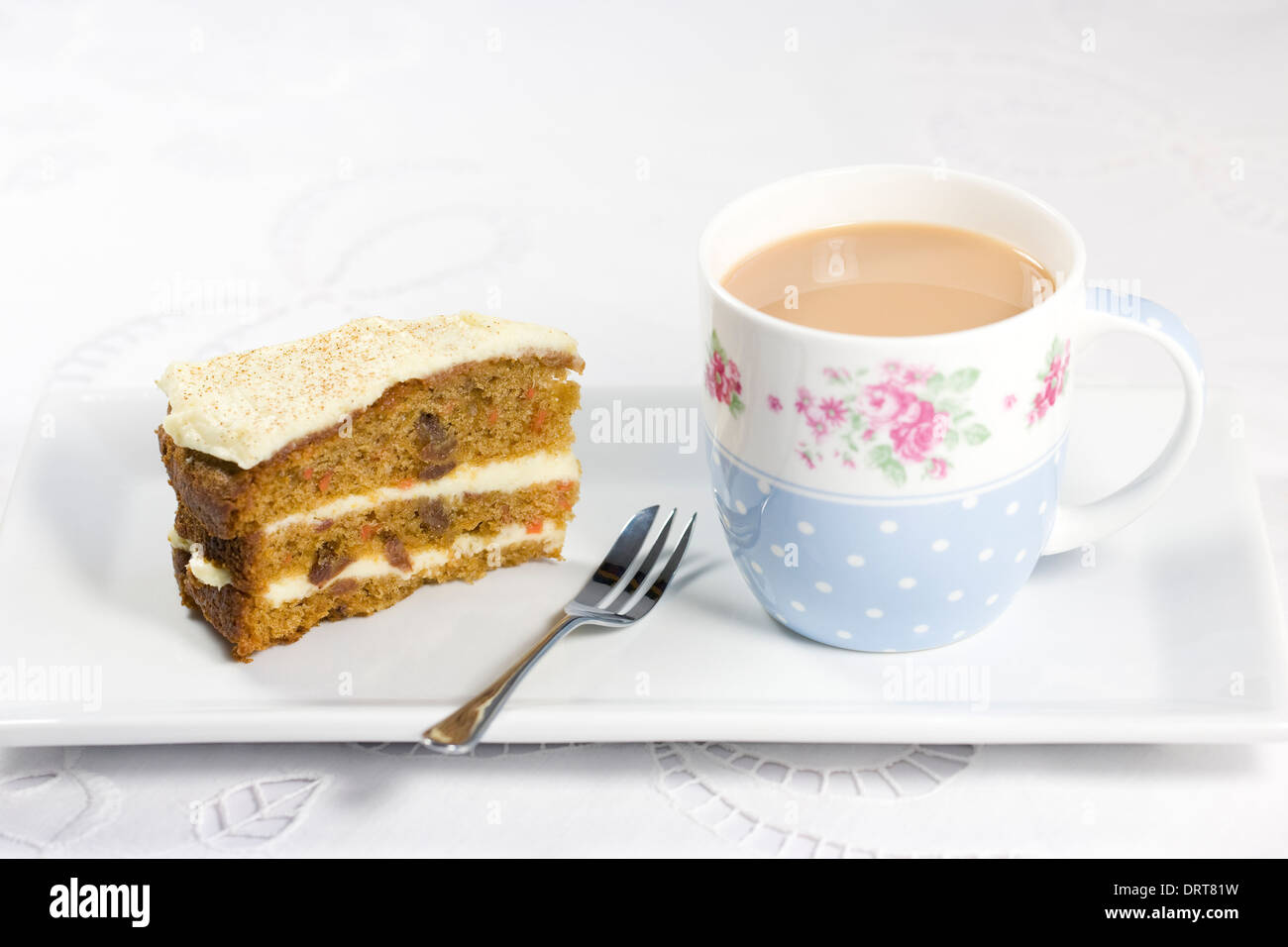 Cup of tea and homemade carrot cake on a white serving plate. Stock Photo