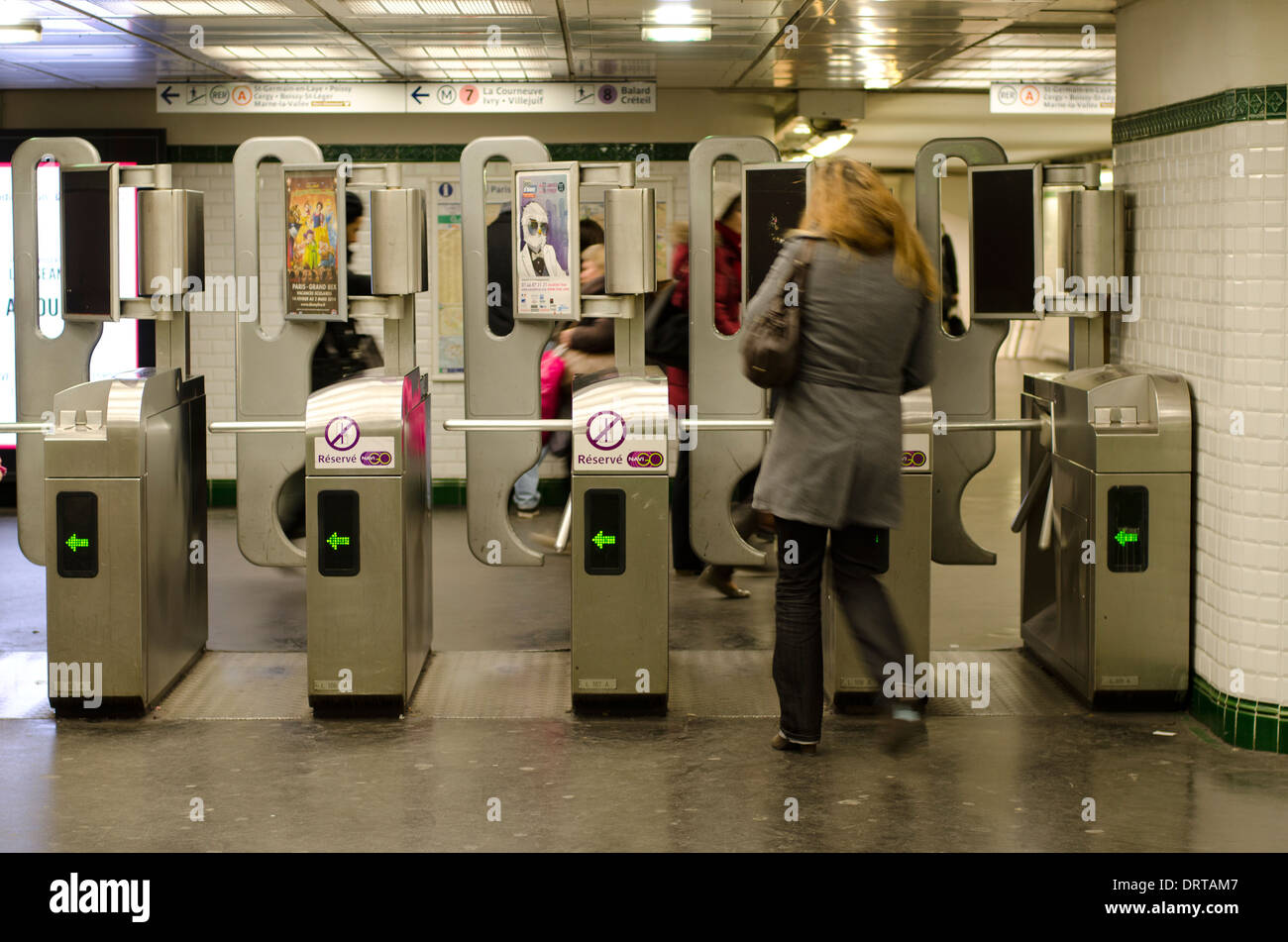 Woman Enters through automated gates to platforms in metro, Paris, France. Stock Photo