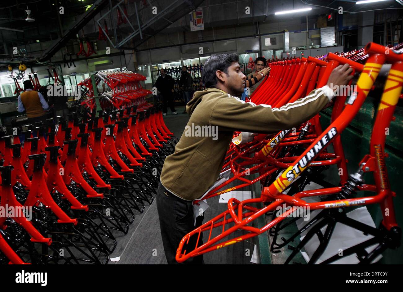(140201) -- PUNJAB, Feb. 1, 2014 (Xinhua) -- A Worker pastes stickers on bicycle parts at a factory at Ludhina in Indian state of Punjab, Feb. 1, 2014. The north Indian state is the hub of bicycle manufacturing. Officials said 40,000-50,000 bicycles are manufactured in the city everyday and exported to Indian states and other countries. The state has around 4000 registered small and large units associated with making bicycle parts. (Xinhua/Javed Dar) Stock Photo