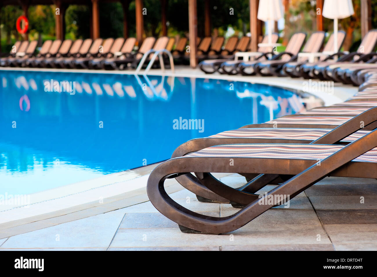 empty sun loungers for sunbathing and swimming pool Stock Photo