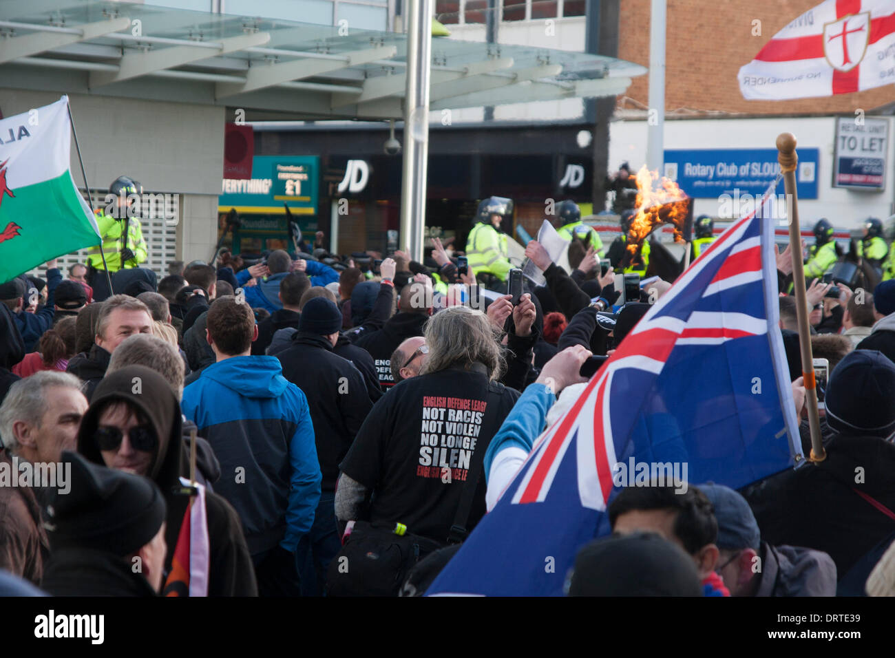 Slough, UK. 1st Feb, 2014.  An Islamic flag burns in the background as several hundred far-right EDL supporters arrive in Slough for an anti- Muslim demonstration. Credit:  Paul Davey/Alamy Live News Stock Photo