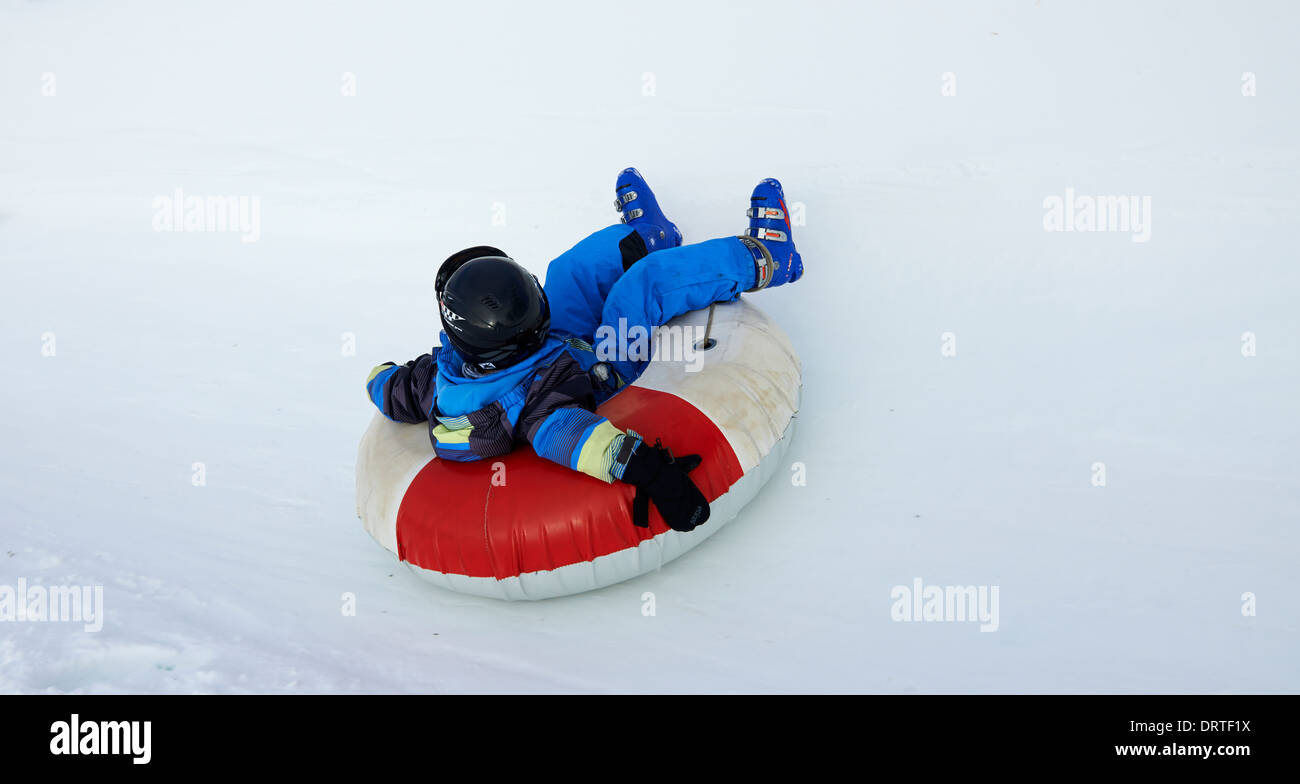 Young boy enjoys a snow tube ride Stock Photo Alamy