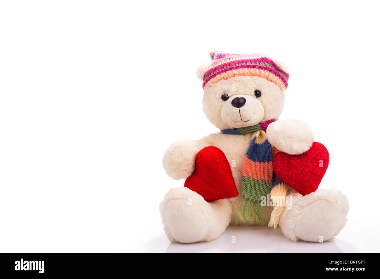 Teddy bear sitting with two valentine hearts isolated on white Stock Photo