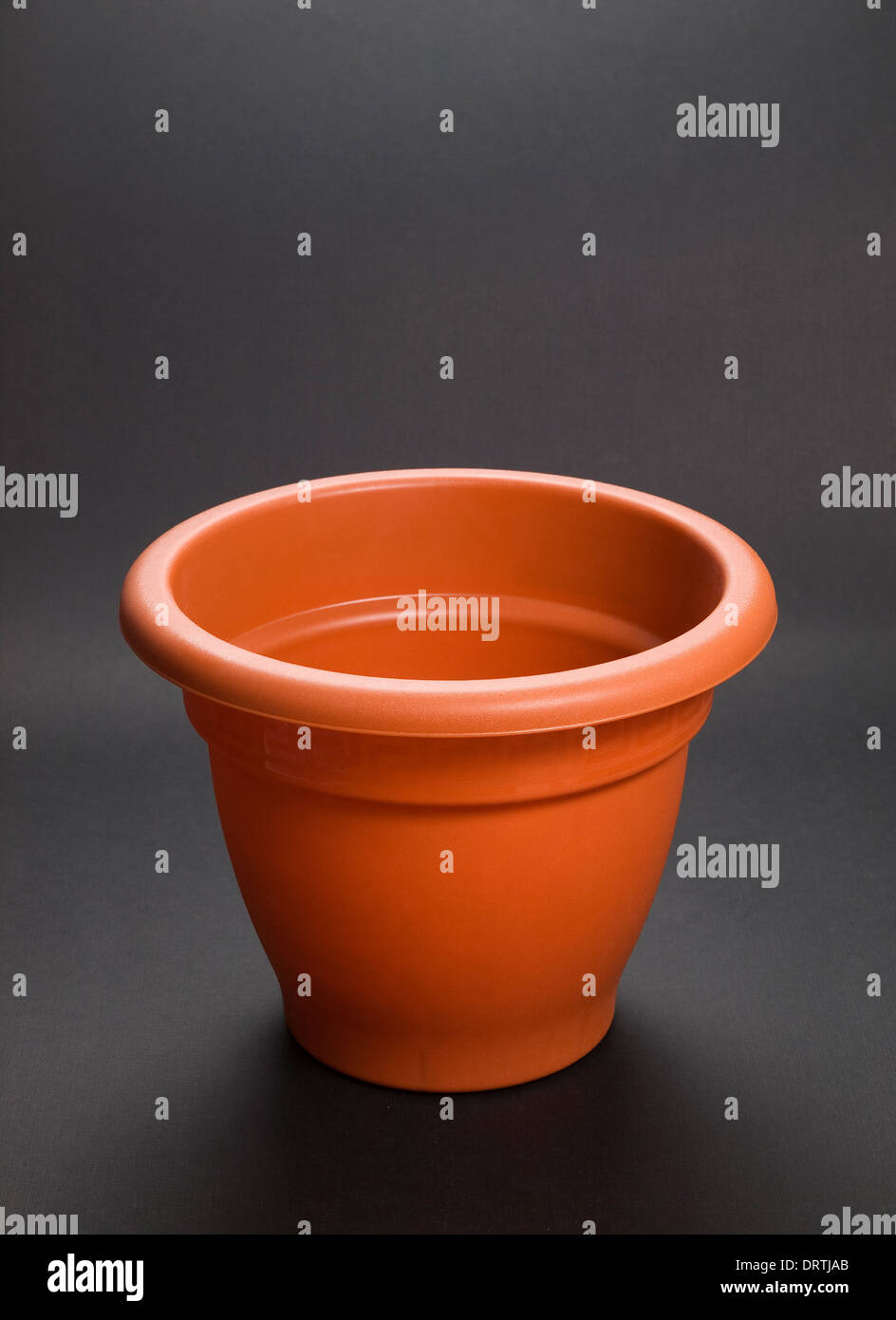 Plastic brown pot isolated on dark background Stock Photo