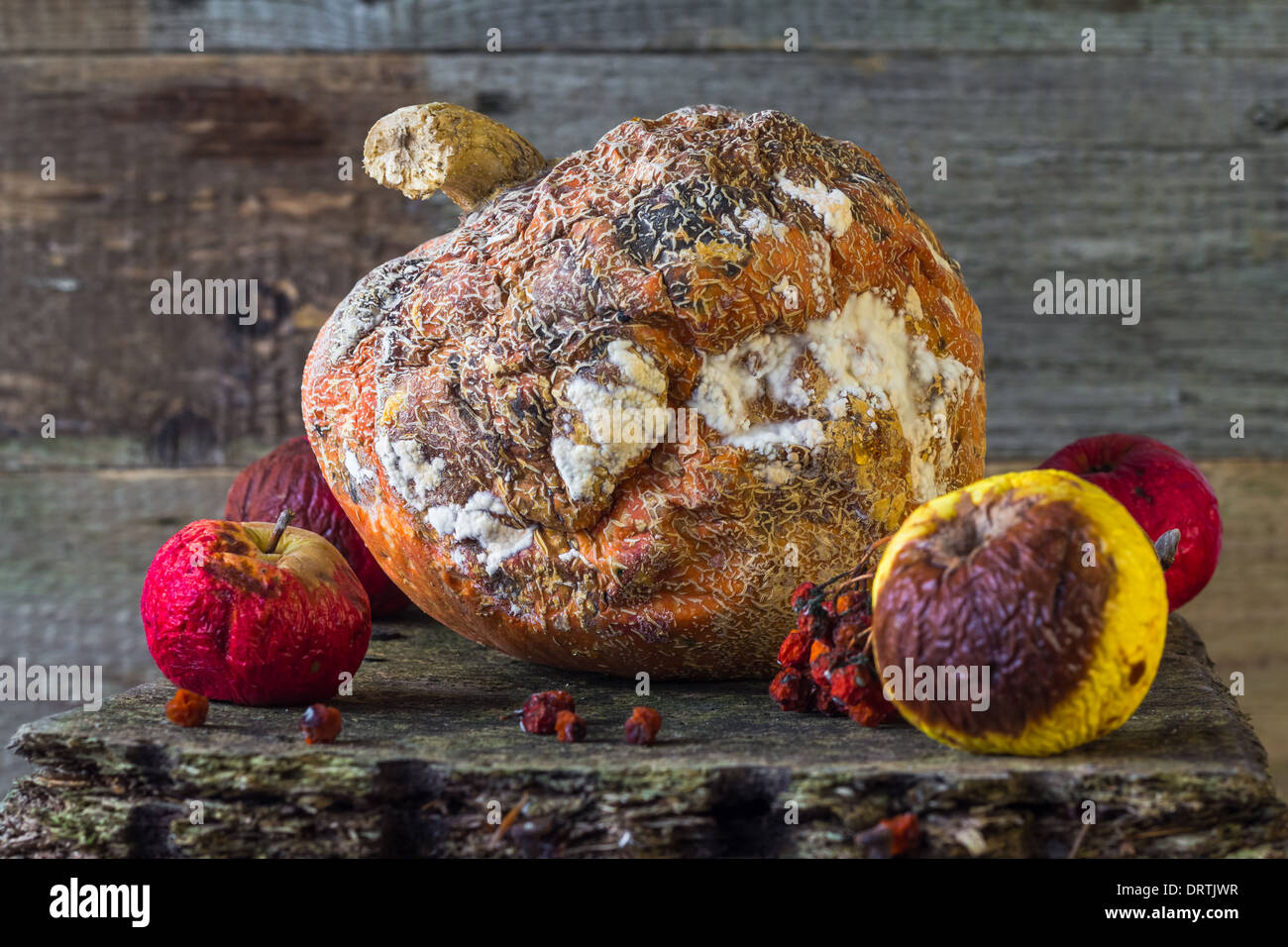 Old and rotten fruit on wooden board Stock Photo