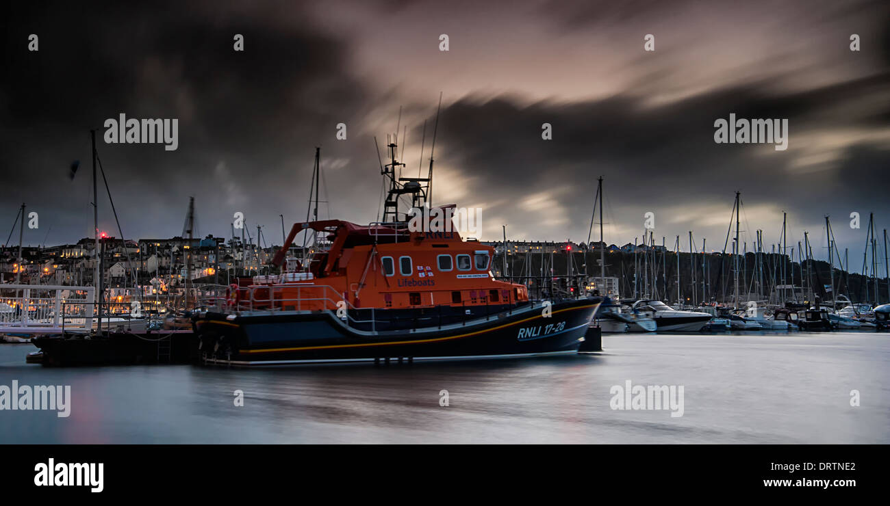 Torbay RNLI 17-28 Lifeboat based in Brixham moored up during a storm. The harbour and marina can be seen in the background. Stock Photo