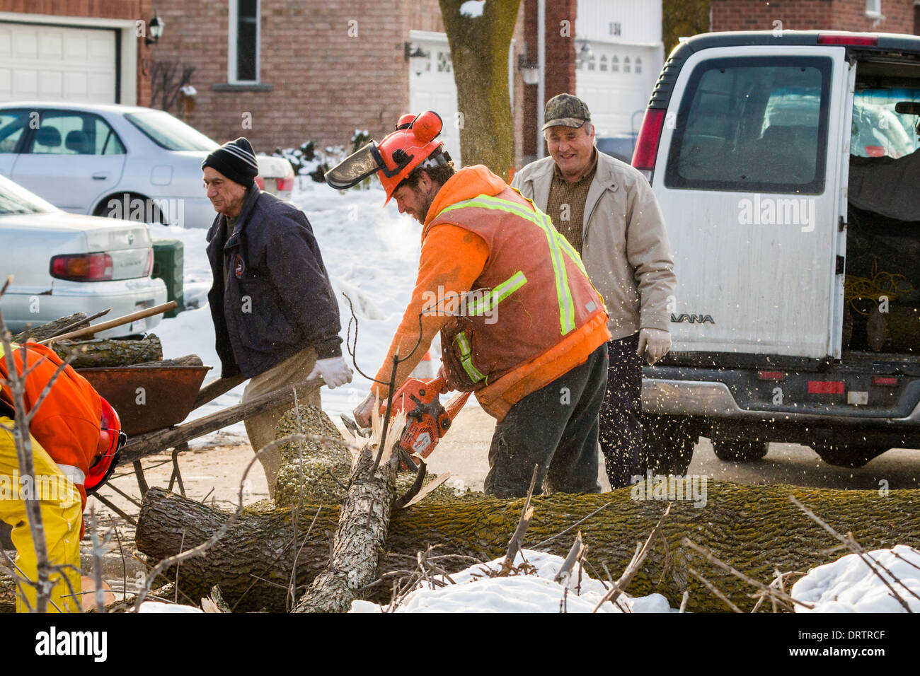 Forestry crews and residents remove tree debris after a crippling ice storm devastated the area and knocked out power for days Stock Photo